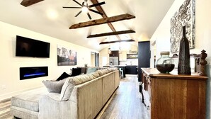 A modern living room with a sectional sofa, a flat-screen TV, and a fireplace. - Eagle's Nest - Beautiful House close to boat launch and local attractions.  (Russellville)