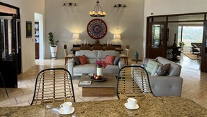 A spacious living room with a high ceiling, a dining area, and a view of the outdoors. - Endless charm in the heart of the Central Valley (Atenas)