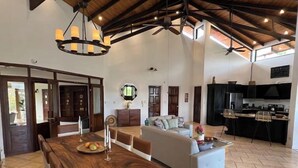 A spacious living area with a dining table, sofa, and kitchen. - Endless charm in the heart of the Central Valley (Atenas)