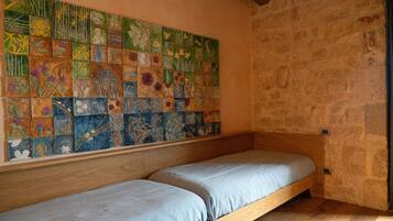 Une pièce avec un lit en bois et un grand mur recouvert de carreaux à motifs floraux.