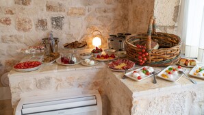 A buffet setup with various food items and a wicker basket. - DONNAPAOLA MODERN FARM (Altamura)