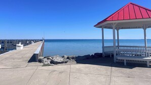 A pier with a gazebo and benches, overlooking calm water.