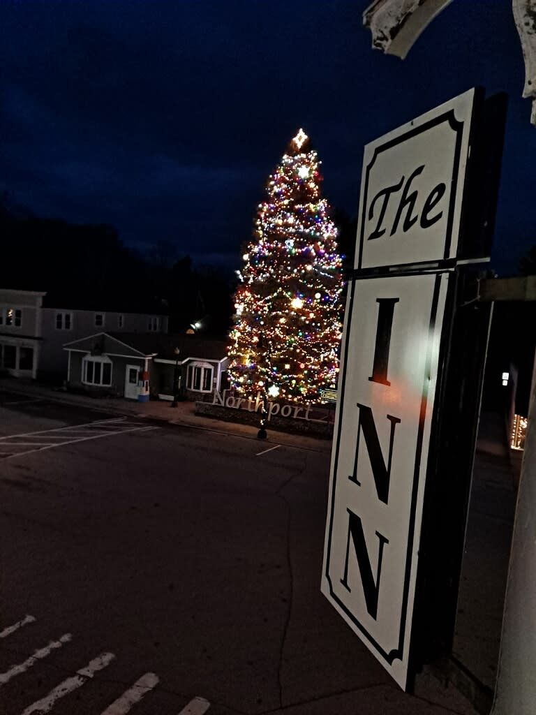 Señal que dice 'The Inn' con un árbol de Navidad al fondo.