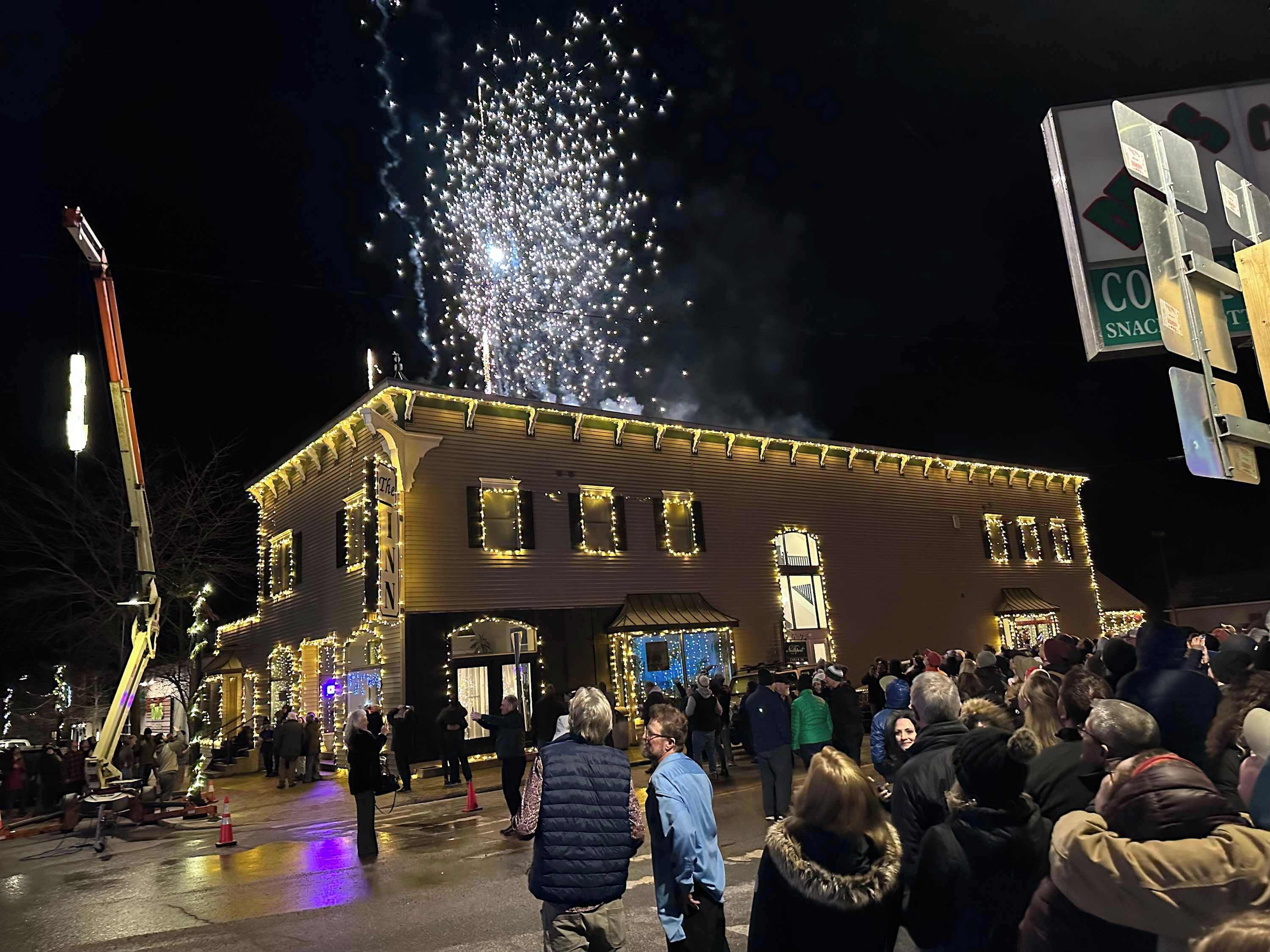 A building with a sign reading "The Inn" and a crowd of people gathered outside.