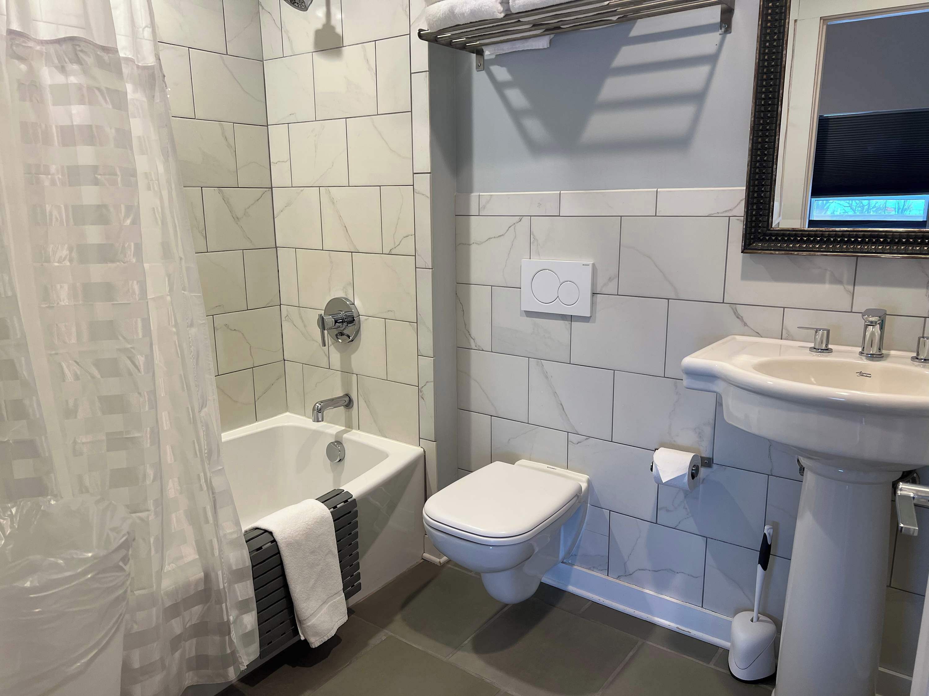 Un baño con bañera, inodoro y lavamanos.