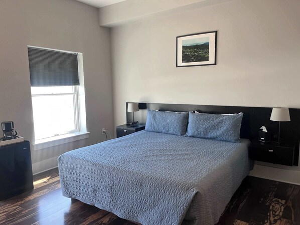 Relax in a stylish room with a large bed, framed artwork, and a convenient coffee maker.