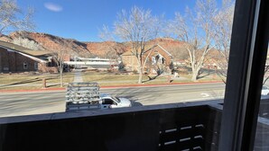 A view from inside a vehicle, looking out at a building with a brick facade and a clear blue sky. - Welcome To The New Kanab Lodge Suite 22 (Kanab)