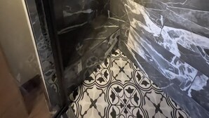 A bathroom with dark marble walls and patterned floor tiles. - Welcome To The New Kanab Lodge Suite 22 (Kanab)