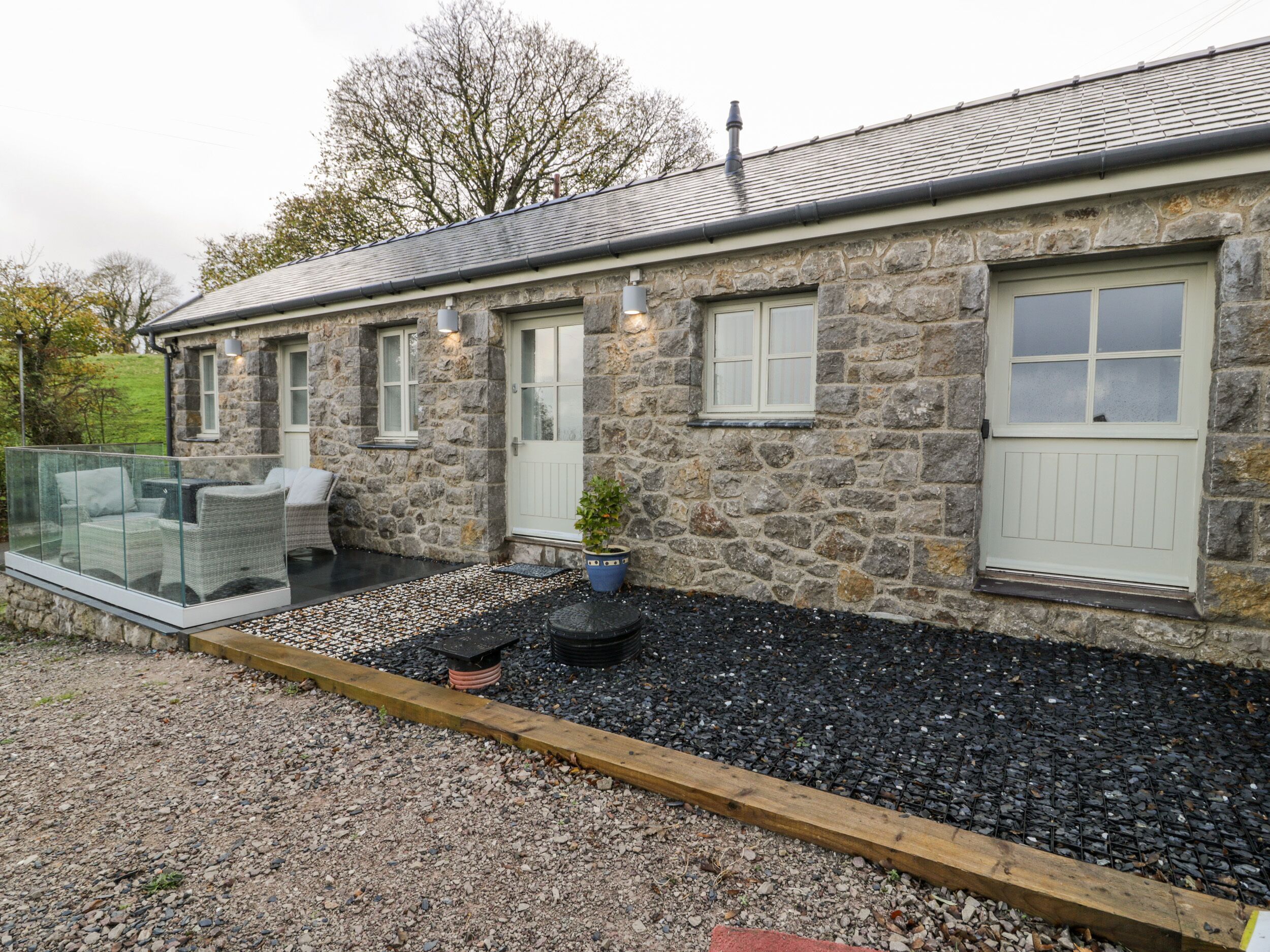 A stone building with a balcony, a door, and a window.