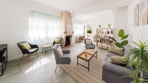 A modern living room with a fireplace, comfortable seating, and a bookshelf. - Villa Paraiso Da Caparica (Almada)