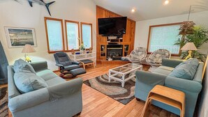 Ein Wohnzimmer mit zwei Sofas, einem Couchtisch, einem Fernseher und einem Kamin.