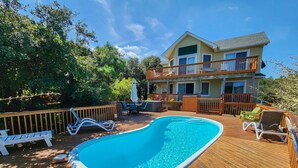 A swimming pool on a wooden deck with lounge chairs and a house in the background. - Top Of THe Hill - High Dune location, 4 BR home w/Private Pool and Dogs Allowed (Southern Shores)