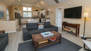 A spacious living area with a sofa, coffee table, and a TV. - Top Of THe Hill - High Dune location, 4 BR home w/Private Pool and Dogs Allowed (Southern Shores)