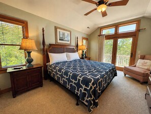A bedroom with a bed, a nightstand, a chair, a ceiling fan, and a window with blinds. - THE SUN ALSO RISES - 6 BR Oceanside, only 200 yards to the beach w/Private Pool & Dogs Allowed (Duck)
