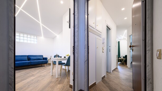 A modern interior with a blue sofa, a white table, and a wooden floor. - Villa In Bed Blue Suite Balcony (Campania)