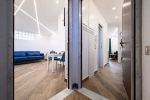 A modern interior with a blue sofa, a white table, and a wooden floor. - Villa in the Blue Suite with a balcony (Campania)