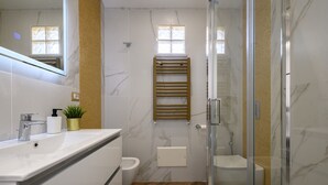 A modern bathroom with a glass shower enclosure, a white sink, and a towel rack. - Villa In Bed Blue Suite Balcony (Campania)