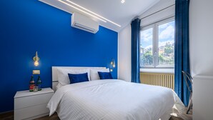 A bedroom with a large bed, white nightstands, and a window with curtains. - Villa In Bed Blue Suite Balcony (Campania)