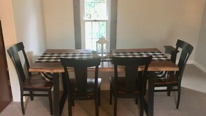Un coin repas avec une table à carreaux et quatre chaises.