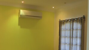 A room with a bed, an air conditioner, a curtain, and a checkered floor. - Orient star hotel (Luxor)