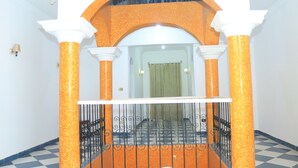 A staircase with an orange and white color scheme, featuring a checkered floor and a metal railing. - Orient star hotel (Luxor)