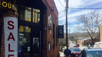 A storefront with a 'SALE' sign, a 'West First' sign advertising lunch and dinner, and a brick building facade.