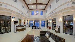 A spacious lobby with a reception desk, seating area, and large windows. - Private Pool, BBQ, Themed Suites, PS5 Just Close to Disney (Four Corners)