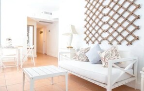 Relax in a serene space with a sofa, side table, and lamp, set against a unique lattice design.