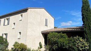 Ein Gebäude mit flacher Fassade, zahlreichen Fenstern und einem Schotterweg.