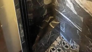 Kylpyhuone, jossa on tummat marmorilaatat ja kuvioitu lattia.