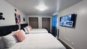A hotel room with two beds, a TV mounted on the wall, and a ceiling fan. - Colorful Shadow-Game Rm, Hot Tub, 5 min from Chisholm Creek (Oklahoma City)