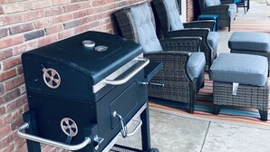 A covered patio with a brick wall, outdoor furniture, and a grill. - Colorful Shadow-Game Rm, Hot Tub, 5 min from Chisholm Creek (Oklahoma City)