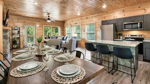 Ein Holzblockhaus mit Essbereich, Küche und Wohnraum.
