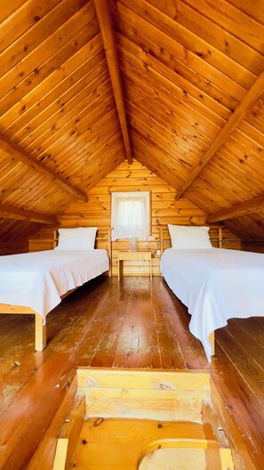 A cabin with two beds, a small table, and a window. - Yelkovan Zeytin Evi (Marmara)