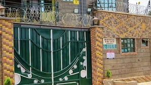 Un cancello con un cartello 'House to Let', un muro in mattoni e una piccola pianta in vaso.
