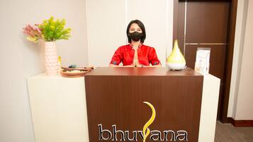 Un comptoir d’accueil orné d’un logo sur lequel on peut lire « bhuvana massage ».