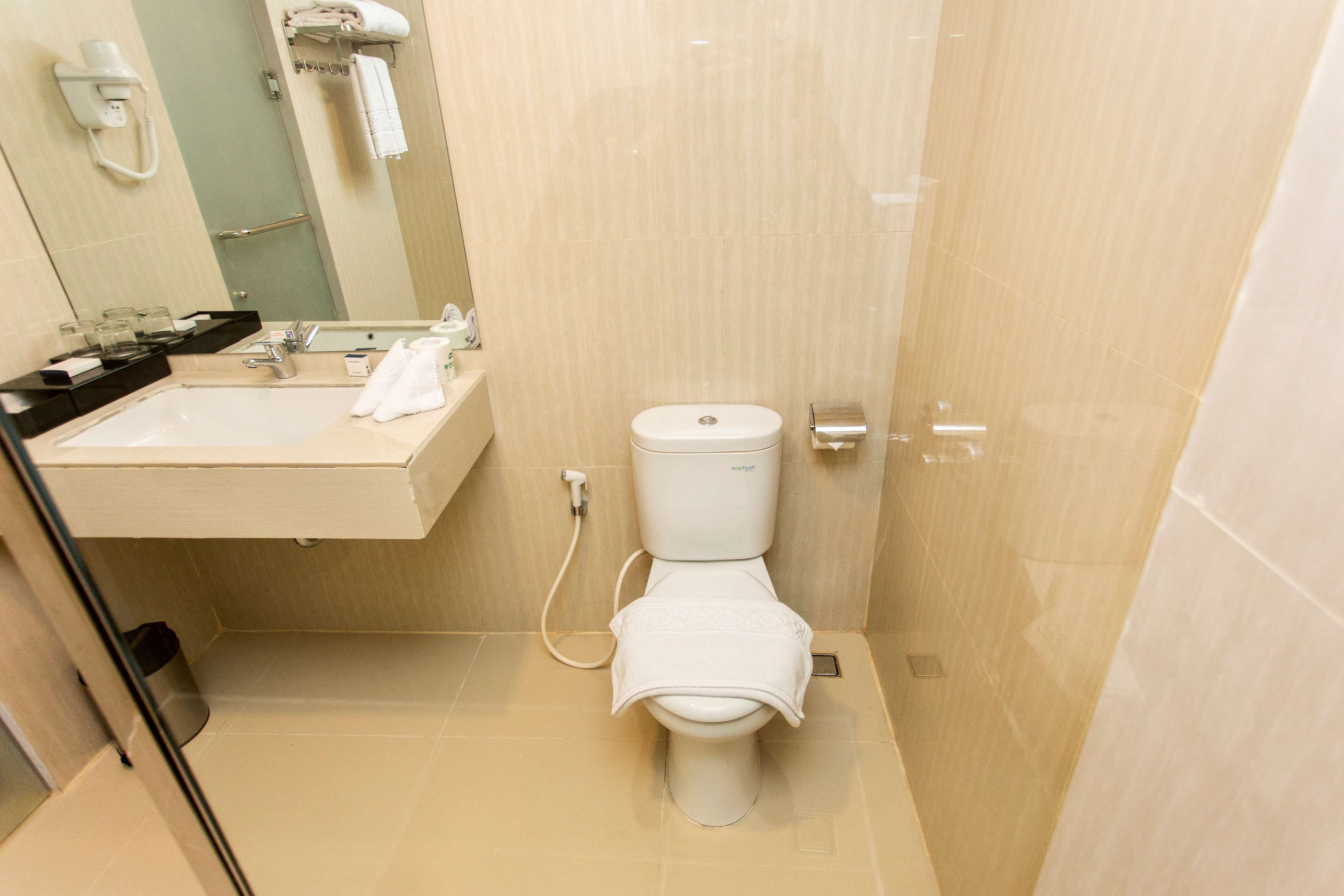 Un baño pequeño y moderno con inodoro, lavamanos y espejo.