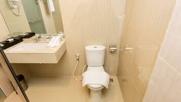Un baño pequeño y moderno con inodoro, lavamanos y espejo.