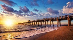 A pier extending into the ocean with waves lapping at its base. - Contemporary Coastal Retreat with 3 Masters, Minutes to beaches (Venice)