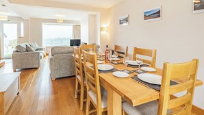 A dining area with a wooden table set for four, surrounded by wooden chairs. - 4 bedroom accommodation in Keswick (Keswick)