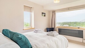 A bedroom with a bed, a window, a radiator, and a view of greenery. - 4 bedroom accommodation in Keswick (Keswick)