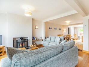 Una sala de estar con chimenea, sofá y comedor.