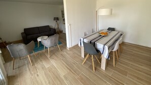 Ein Essbereich mit einem Tisch für vier Personen, einer Couch und einer Lampe.
