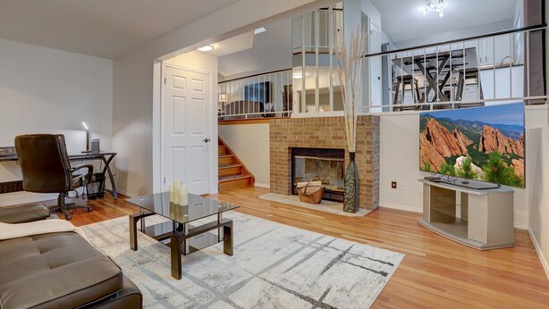A spacious living area with a fireplace, a dining table, and a comfortable seating area.