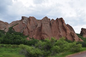 A natural landscape with a prominent rock formation and green vegetation.