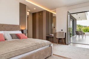 Un dormitorio moderno con una cama grande, un escritorio y vistas al exterior.