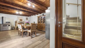 A kitchen with wooden flooring, a dining table with chairs, a refrigerator, and wooden cabinets. - Stone Gem - Villa Katarina with Private Pool (Nedešcina)