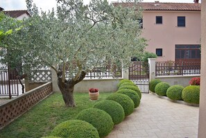 Surrounded by lush greenery and vibrant flowers, this serene outdoor space offers a tranquil retreat.