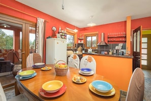Enjoy meals in this dining area with a table set for a meal, surrounded by a sofa and chairs.