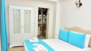 A hotel room with a bed, a wardrobe, and a bathroom visible through an open door. - Merve Butik Otel (Didim)